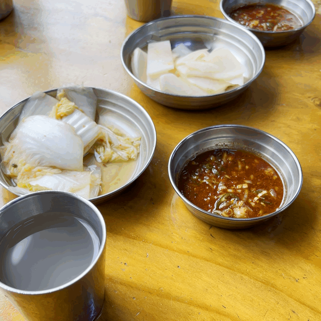 필동면옥에서 제공되는 기본 반찬인 백김치, 무절임과 면수