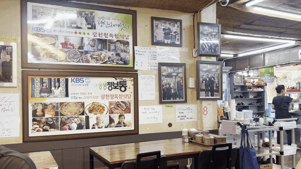 수많은 방송 출연 액자와 유명인 사인이 가득한 광천식당의 내부 전경. The interior of Gwangcheon Sikdang, with walls decorated with photos of celebrity visits and features on Korean TV shows.