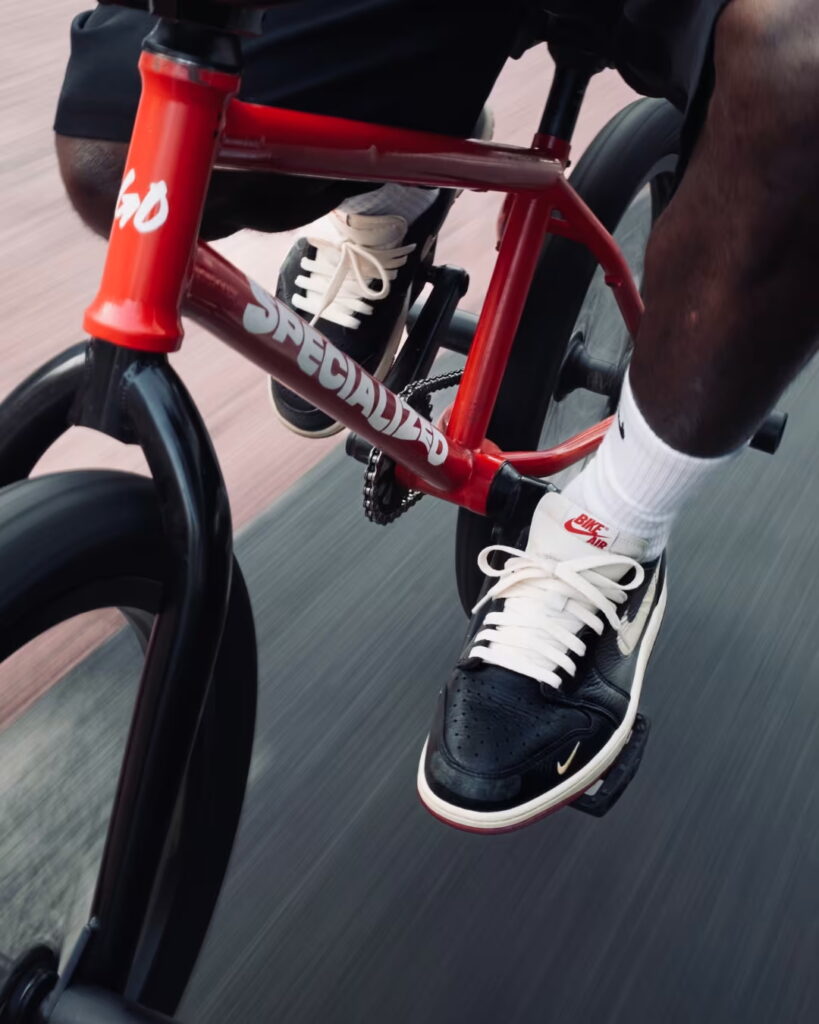 BMX 자전거를 타는 시점에서 바라본 나이젤 실베스터 에어 조던 1 로우 착용샷. An on-feet, point-of-view shot of the Nigel Sylvester Air Jordan 1 Lows while riding a BMX bike.