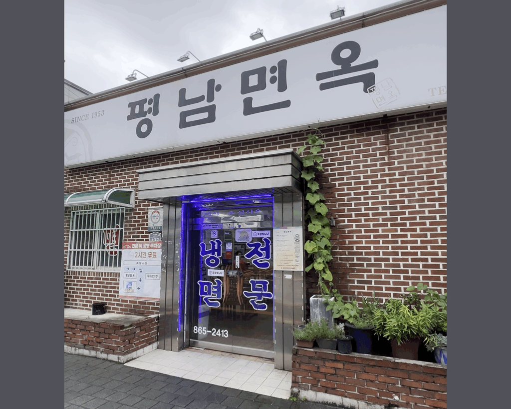 'SINCE 1953' 문구가 보이는 동두천 평남면옥의 벽돌 건물 외관과 출입문. The brick exterior and entrance of Pyeongnam Myeonok in Dongducheon, with a 'SINCE 1953' sign.