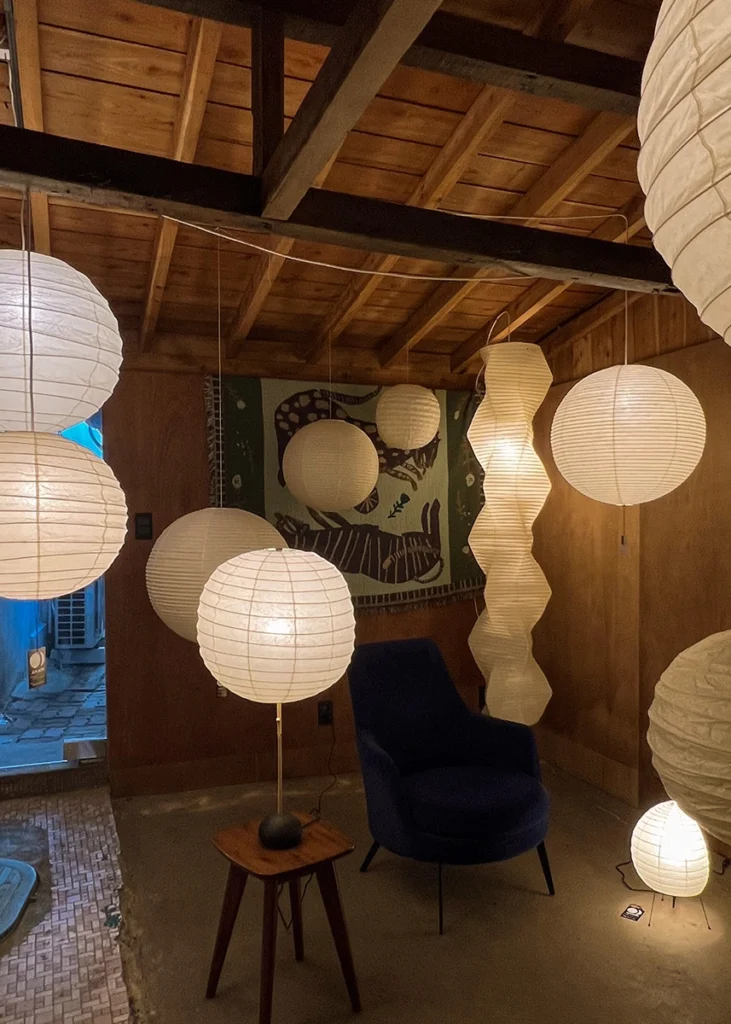 어두운 공간에서 빛을 강조한 아카리 조명 설치 연출 Akari lamps highlighted in a dim exhibition room at Chunilgaok