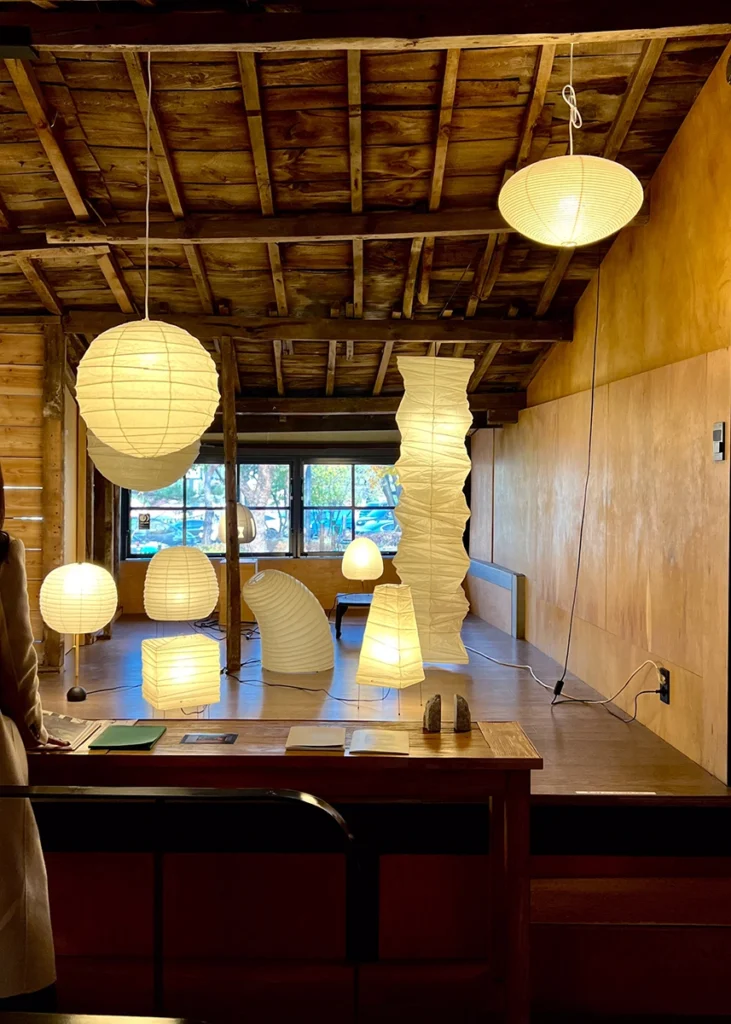 종이 조명 조형물들이 전시된 아카리 조명 설치 공간 전경 Sculptural paper Akari light forms displayed in the exhibition interior