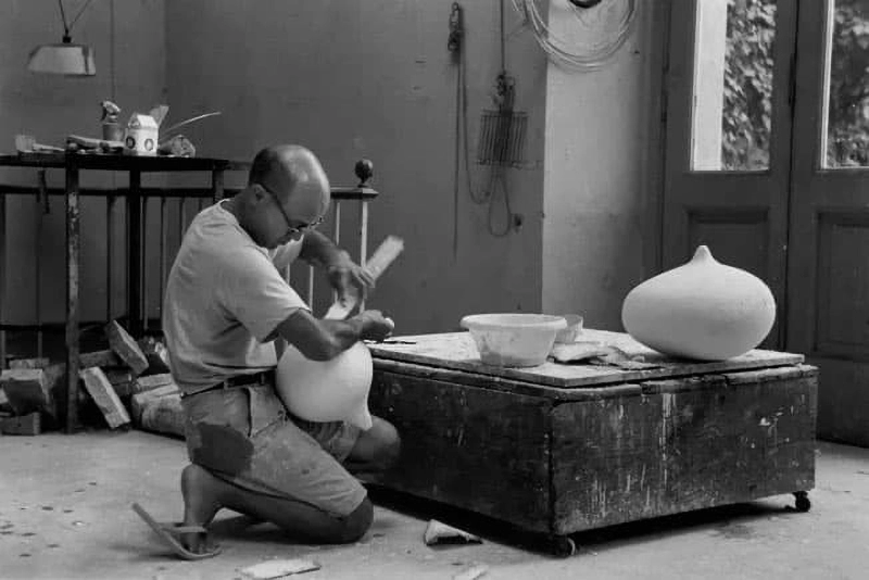 흙 조형 작품을 손으로 다듬고 있는 작업 중의 이사무 노구치 Isamu Noguchi shaping a clay sculpture during his creative process